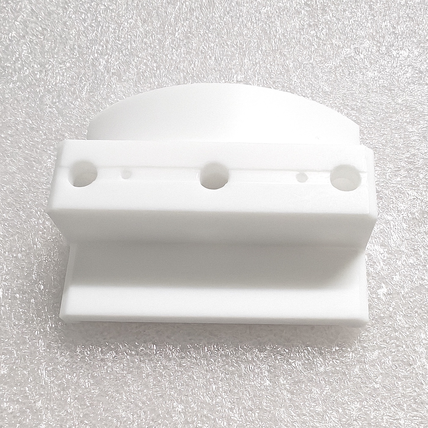 Custom-machined PTFE components with mounting holes and precise structural features